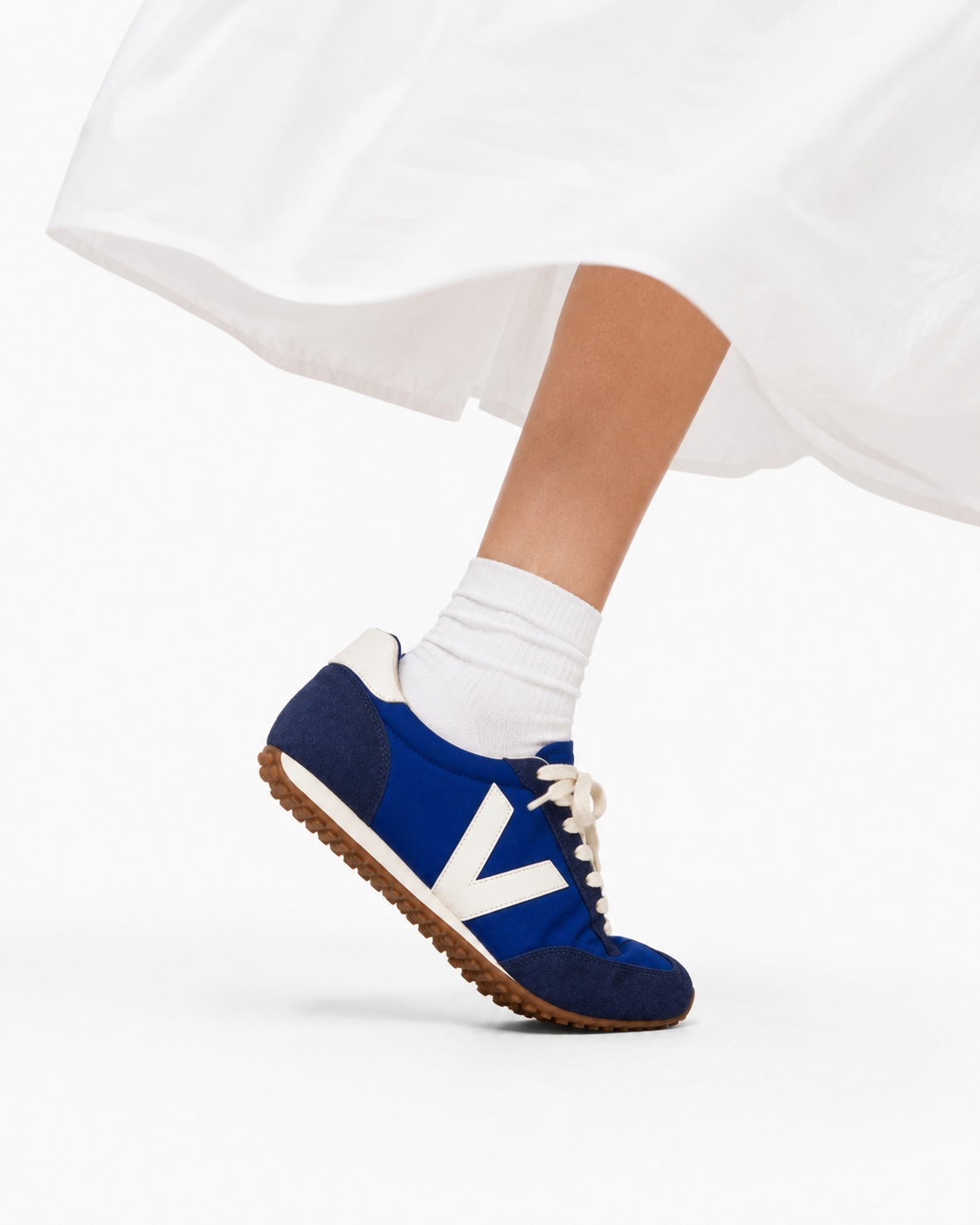 Modella seduta su una scalinata con sneaker VELUNA